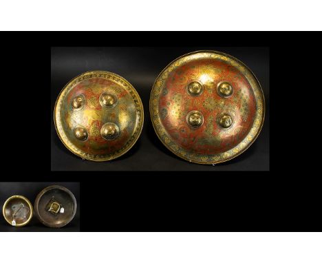 Antique Indo-Persian Decorative Shields Two circular brass shields with ornate etched patterning throughout. The larger depic