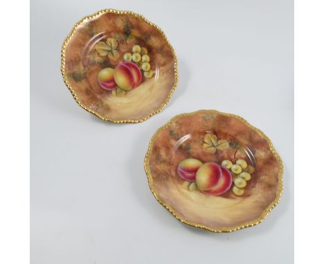 A pair of Royal Worcester side plates, decorated with fruit to a mossy background by J Smith, to a shaped gilt edge, diameter