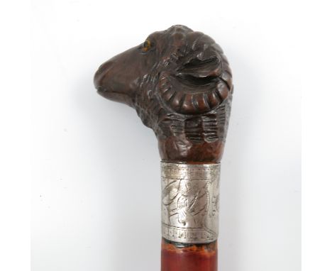 A walking stick, the handle carved with a rams mask, with engraved collar and red painted shaft, height 37ins