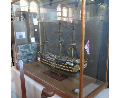 A wooden model, of H.M.S Victory, in a large oak and glass display case, 38ins x 47ins