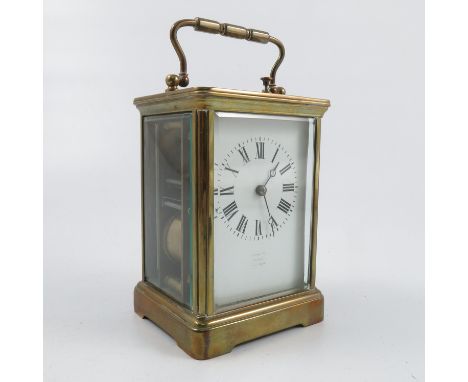A brass cased repeating carriage clock, with white enamel dial and Roman numerals, height including handle 7ins, together wit