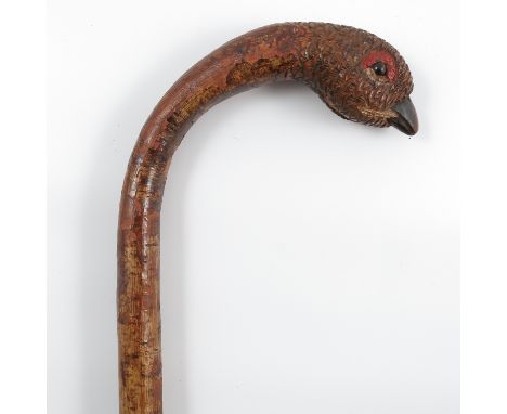 A walking stick, the handle carved and painted with a Partridge mask, with engraved silver collar, Dublin 1911, height 37ins