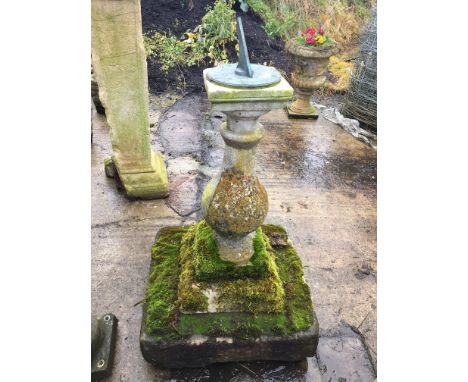 A sundial, raised on a concrete baluster shaped column, to a stepped base, height 44.5ins, diameter of sundial 7.25ins