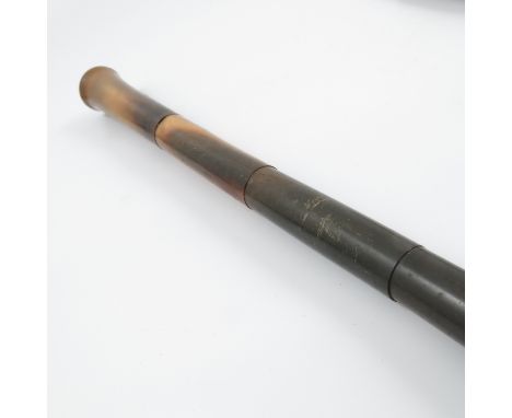 A horn walking stick, the shaft made in sections, the pommel top set with an enamelled disc, height 34ins