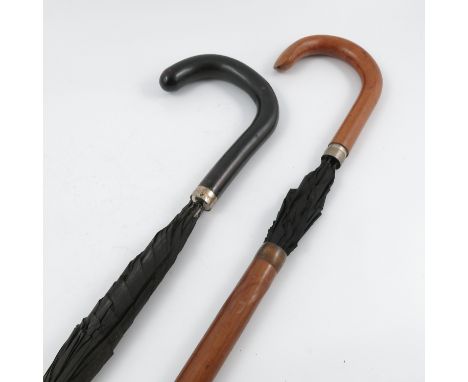 An Earnest Hugendubel combined umbrella walking stick, together with another similar umbrella walking stick