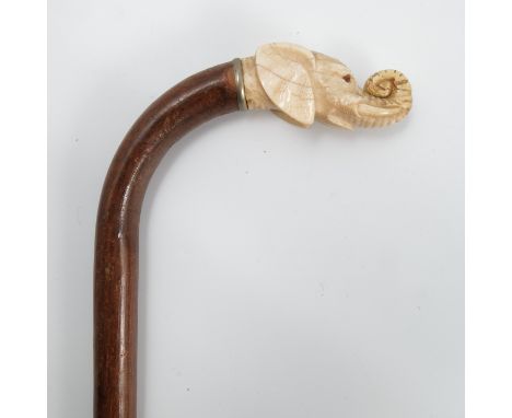 A 19th century walking stick, the carved ivory handle formed as an elephant mask, height 36.5ins