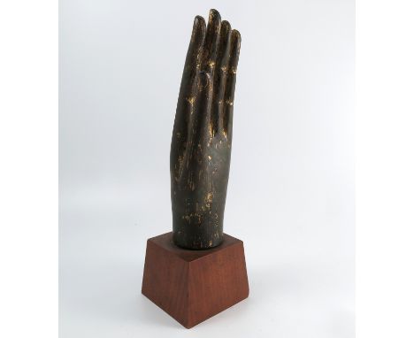 An Eastern metal model, of a hand, with remains of gilt decoration, on a wooden base, overall height 16.5ins, height of hand1