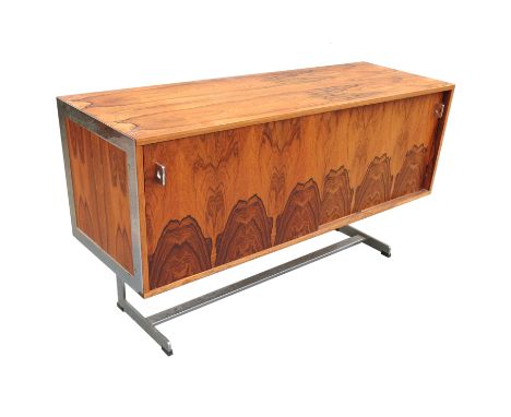 A 1970s rosewood sideboard, having two cupboards each side with a glass shelf, and chrome supports, attributed to Merrow Asso