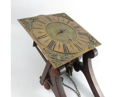 A long case clock movement, mounted on a mahogany bracket, the square brass dial, with single finger, Roman numerals and pier