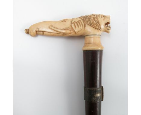 A 19th century walking stick, the carved ivory handle formed as the masks of a lion and an elephant, height 33ins