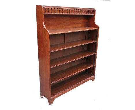 A set of oak bookshelves, having a central top shelf with spindle mounted gallery and fitted with four additional shelves bel