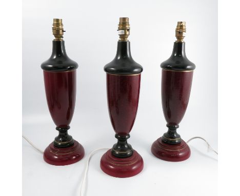 Three wooden lamp bases, of urn form, decorated in black and mottled red, height 17.5ins excluding shades