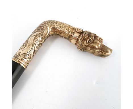 A Victorian ebonised walking stick, the gilt metal handle formed as a dogs head, the collar engraved New Year 1869, to scroll