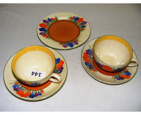 Two Bizzare by Clarice Cliff cups & saucers and an additional side plate, each painted in the Autumn Crocus pattern, in good 