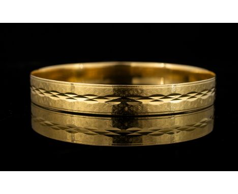 An 18ct Gold Italian Bangle Yellow gold bangle with textured finish and etched diamond pattern. Marked 750 VI 330, diameter a
