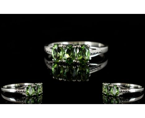 Green Apatite Three Stone Ring, three oval cut natural green apatites, totalling 1.5cts, set in a classic style in silver; th