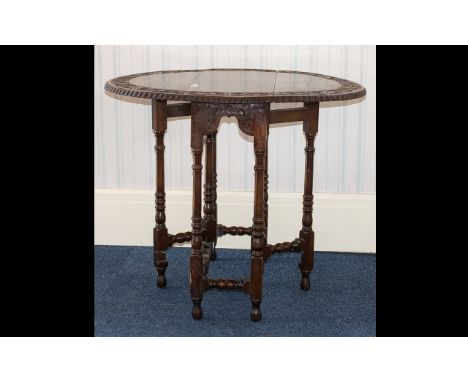 A Carved Oak Drop Leaf Gate Leg Table carved top, turned support. Height 28 inches, length 25 inches, Celtic style carving to