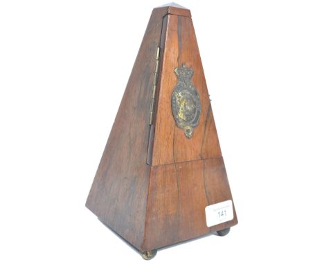 An early 20th century century rosewood cased metronome being of pyramidal form having a brass armorial plaque stamped " METRO