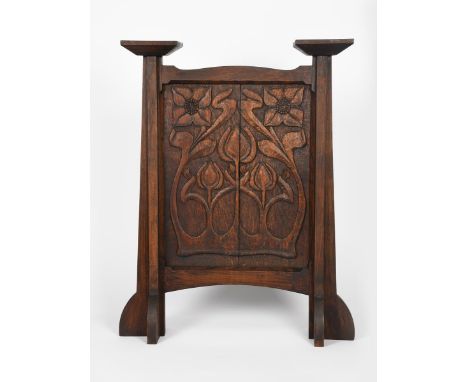 An Arts and Crafts oak firescreen in the manner of Arthur Simpson, the rectangular panel carved with Art Nouveau flowers and 