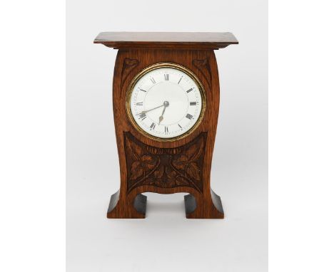 An Arts and Crafts carved oak mantel clock, swollen rectangular form with over-hanging mantel, carved with stylised flower an