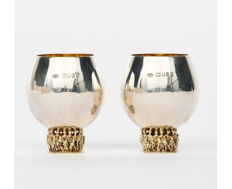 A pair of Stuart Devlin silver whisky tots,  on cast silver-gilt caryatic bases, the silver bowls with gilt interior, stamped