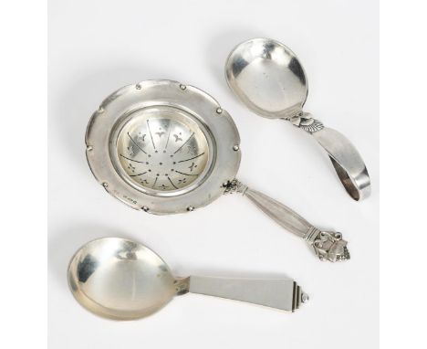 A Georg Jensen Pyramid caddy spoon designed by Harald Nielsen, a Georg Jensen Acorn pattern tea strainer and another caddy sp
