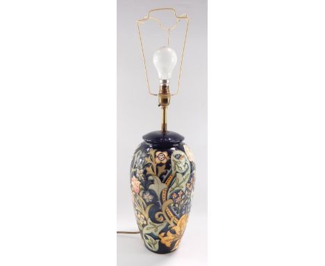 A Moorcroft pottery table lamp, decorated in the Gold Lily pattern against a cobalt blue ground, 33cm high.