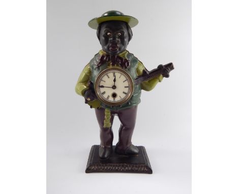 A black cast iron minstrel banjo player clock, enamel dial bearing Roman numerals, the case with moving eyes, 38.5cm high.