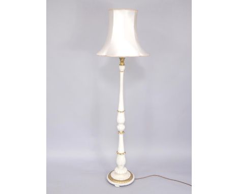 A white and gilt painted early 20thC standard lamp, with fluted and leaf carved decoration, on a circular base, on bun feet, 