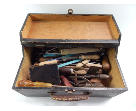 A black painted wooden tool box containing hammers, braces, screwdriver, and sundry tools.