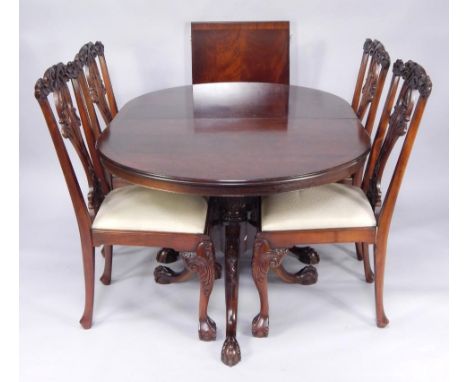 A Chippendale style twin pedestal mahogany dining table, each pedestal with leaf carving over three cabriole legs and ball an