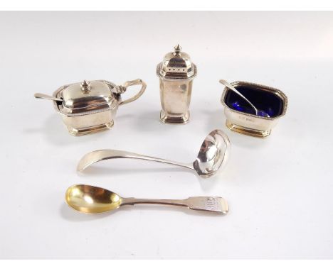 A George VI three piece condiment set, with spoons and blue glass liners, Birmingham 1938, cream ladle, Sheffield 1959, and a