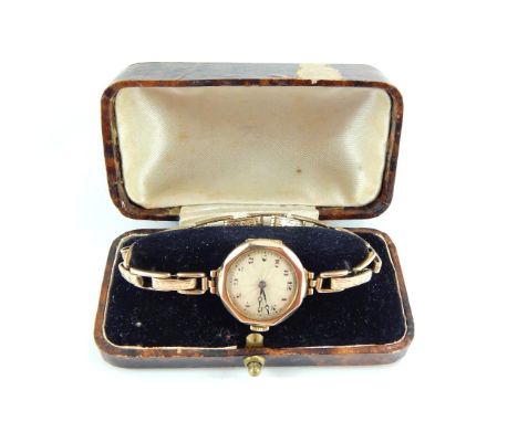 An Ovis lady's 9ct gold octagonal cased wristwatch, engine turned champagne dial bearing Arabic numerals, on expanding plated