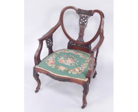 A Victorian mahogany and line inlaid tub nursing chair, with carved splat, overstuffed woolwork tapestry seat, raised on cabr