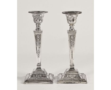 A pair of Edwardian Adam style silver plated candlesticks.   CONDITION REPORT:  One candlestick when placed on a flat surface