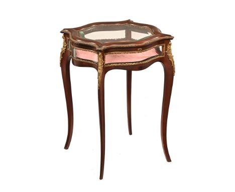A continental mahogany and gilt metal bijouterie table, late 19th/early 20th century of shaped outline with bevelled glass to