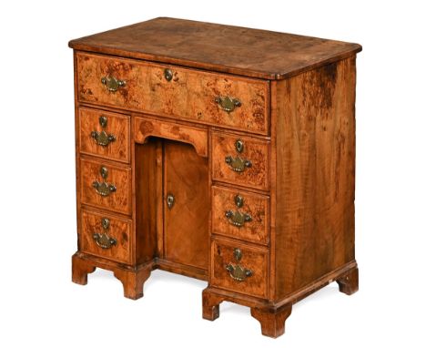 A George III antique walnut kneehole desk, with secretaire drawer above a slide cupboard and six drawers with brass drop hand