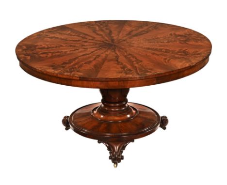 A William IV flame mahogany segmented breakfast table, with snap action and circular base raised on three scroll feet with ca