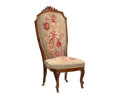 A Victorian walnut nursing chair, with woolwork tapestry back and seat and raised on short front cabriole legs terminating in