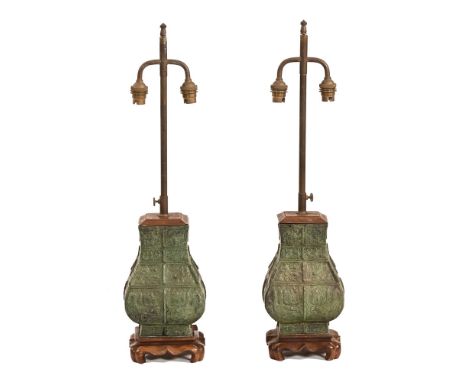 A pair of Chinese green patinated metal table lamps, each raised on a wooden base.  Height excluding light fitting section 26