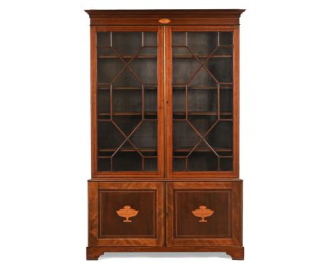 An Edwardian inlaid mahogany bookcase on cupboard, with moulded cornice above a pair of glazed doors with wooden astragals en