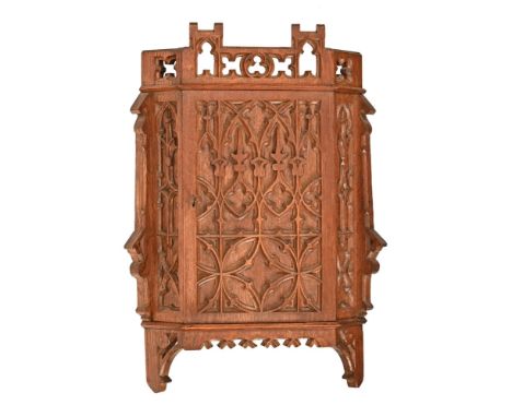 An oak Arts & Crafts Gothic corner cabinet, of small form with internal shelf.  Height 58 cm, width 37 cm, depth 24 cm (see i