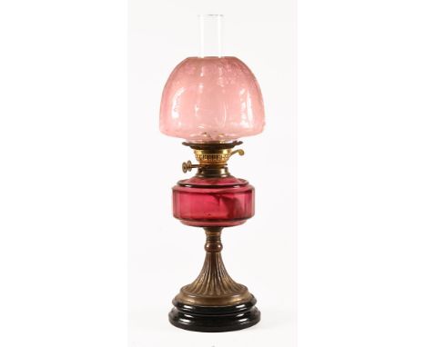 A 19th century oil lamp, with etched glass shade and cranberry glass reservoir.  Height including chimney 58 cm.   CONDITION 