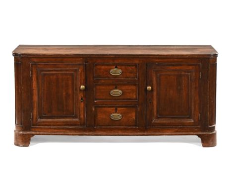 An 18th century oak dresser base, with rounded corners and fitted with a series of drawers and cupboards and raised on corner