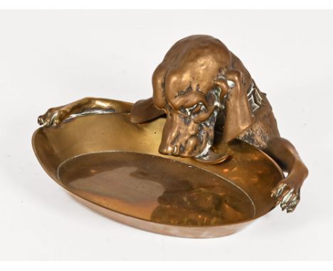 A Victorian novelty brass inkwell, in the form of a hound drinking from a bowl.  Width 27.5 cm.   CONDITION REPORT:  The inkw