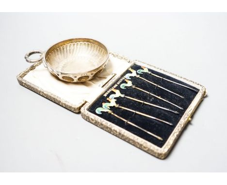 A 1930's silver taste vin and a cased set of six sterling and enamel cocktail sticks.