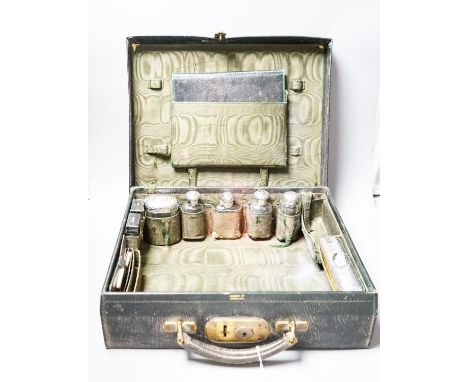 An Edwardian Harrod's traveling toilet case, fitted with six silver mounted toilet accessories, including an associated hip f