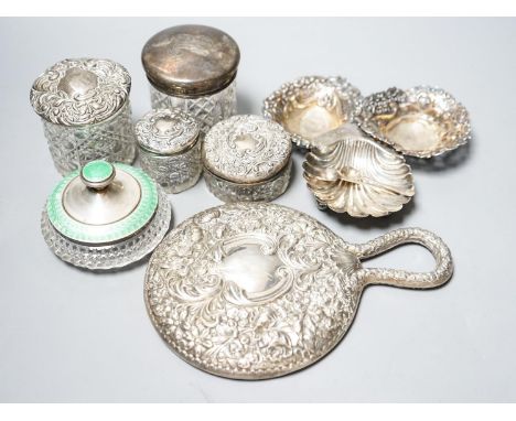 A silver and enamel mounted glass toilet jar, four other toilet jars, a hand mirror and three small silver dishes.