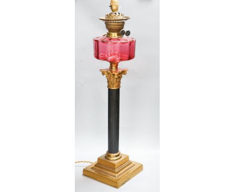 And early 20th century Corinthian column brass and cranberry glass oil lamp, converted for electricity, total height 70 cm