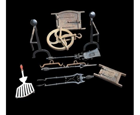 A pair of wrought iron fire dogs, two cast inglenook fireplace doors, a group of wrought iron fire irons and other items.